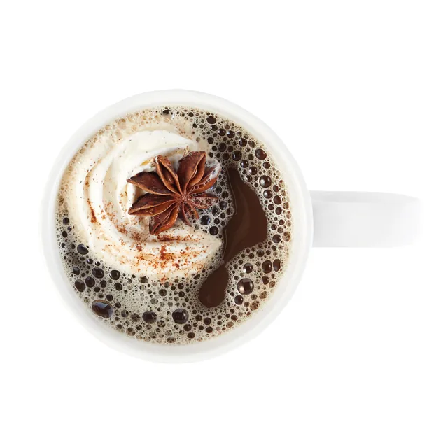 A chai latte from above with whipped cream and star anise