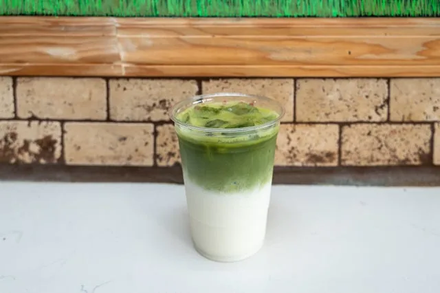 A layered iced matcha in a tall cup