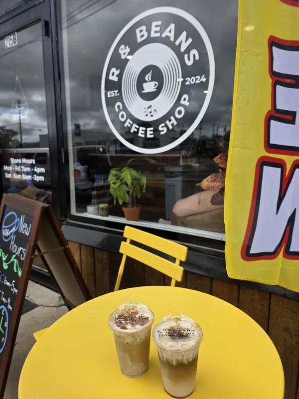 Two iced drinks on the yellow table by the front window